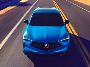 2026 Acura ADX A-Spec shown in Double Apex Blue Pearl II, driving on the road