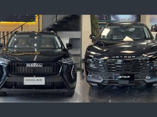 Two black SUVs (Haval and Jetour) displayed indoors at a car dealership showroom.