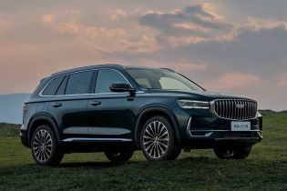 Geely Xingyue L SUV parked on a grassy field under a sunset sky.