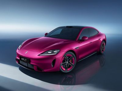 A sleek magenta luxury electric sedan with a sporty design, black roof, and modern LED headlights.