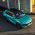 A turquoise Fengxing T5 EVO SUV with a black roof, captured in an aerial view, parked on an asphalt surface near a building, showcasing its sleek and modern design.