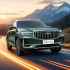 Geely Xingyue L SUV driving on a road with a mountainous sunset background.