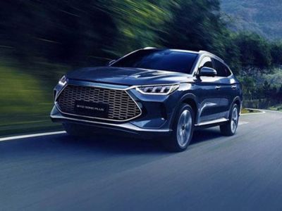 Dark SUV (BYD Song Plus) driving on a curvy road, surrounded by green mountains (motion blur effect).