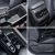 Four close - up views of a car's interior details, including storage compartments, air vents, and seat adjustment parts.