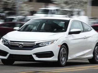 White Honda Civic Coupe: Sleek two-door coupe in motion on a city street, showcasing modern design and dynamic performance.