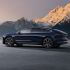 Side view of a dark blue NIO ET9 electric car with snow-capped mountains in the background.