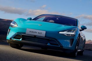 Front view of a turquoise Xiaomi SU7 on the road.