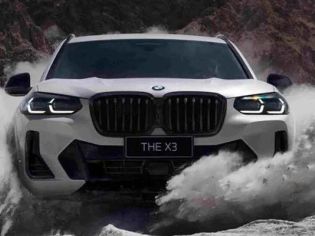 Front view of a white BMW X3 ("THE X3" badge) driving through splashing water in a rugged, mountainous area, highlighting its off-road capability and bold design.