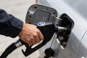 A gas station attendant is filling up a car