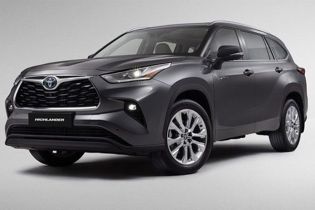 Gray Toyota Highlander SUV (side-front view), illuminated headlights, "HIGHLANDER" badge, plain light backdrop.