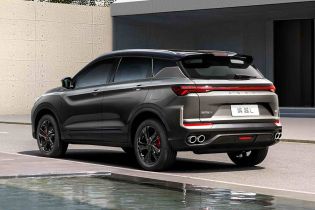 Rear view of Geely BinYue L SUV by a building and water.