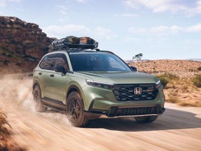 The 2026 Honda CR-V Trailsport Hybrid is driving on a dirt road
