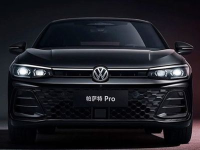 Front view of the black Volkswagen Passat Pro sedan, featuring illuminated headlights and a honeycomb grille, set against a dark background with red accents, highlighting its modern and bold design.