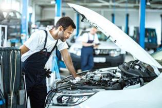 Workers are performing maintenance on the car