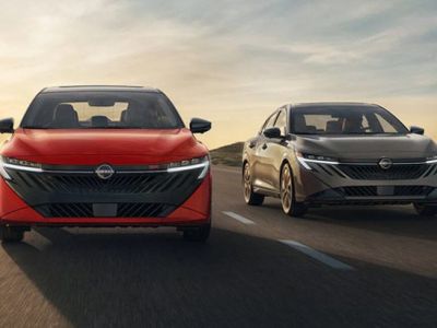 2026 Nissan Sentra view 2 Sentras driving side by side road sunset behind them.