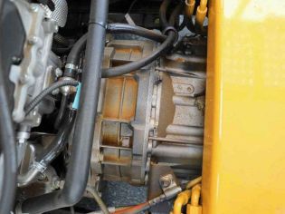 Close - up of a rusty mechanical component with hoses, likely in an engine bay.