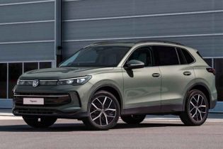 A light green Volkswagen Tiguan SUV parked in front of a modern industrial building.
