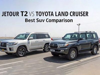 "JETOUR T2 VS TOYOTA LAND CRUISER: Best Suv Comparison. Two SUVs (silver & black) parked on a road; the black one shows Toyota badging, set against an open, industrial backdrop."