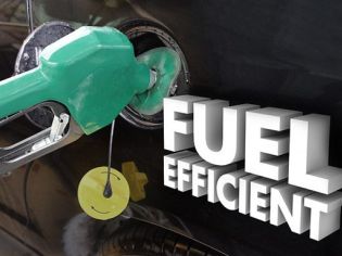 Close-up of a green fuel nozzle inserted into a car's fuel tank, with "FUEL EFFICIENT" text displayed.