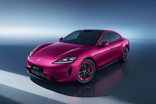 A sleek magenta luxury electric sedan with a sporty design, black roof, and modern LED headlights.