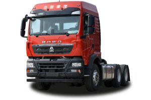 Front - side view of a red HOWO truck tractor unit, isolated on a white background.