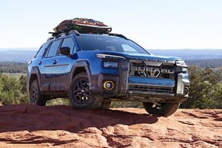 Mud-streaked blue off-road Mud-streaked blue off-road SUV parked on a red rock overlook, with gear loaded on its roof rack and expansive desert views behind. parked on a red rock overlook, with gear loaded on its roof rack and expansive desert views behind.