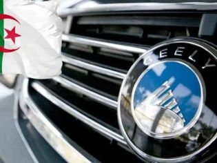 Close-up of a Geely car emblem on a grille, paired with the Algerian flag in the background, linking the automaker to Algeria.