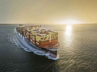 A large MSC container ship sailing on the sea during sunset.