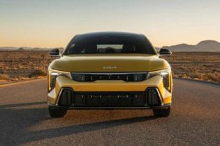 2026 Kia K4 Hatchback, parked in the middle of a desert road at golden hour, front-view