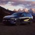 A dark - colored Xpeng G9 SUV parked with a stunning mountain range and a colorful sunset sky in the background.