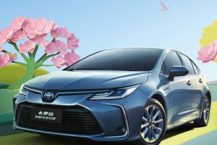 A blue Toyota Corolla Intelligent Electric Hybrid car in a scenic, spring - like setting with pink flowers and birds