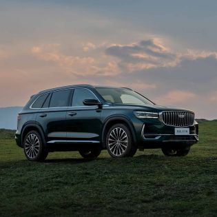 Geely Xingyue L SUV parked on a grassy field under a sunset sky.