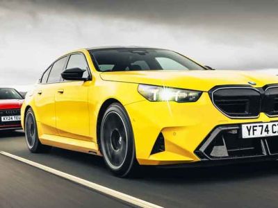 A yellow BMW (license plate YF74 CZZ) and a red Audi (license plate KY24 TEU) driving on a road.