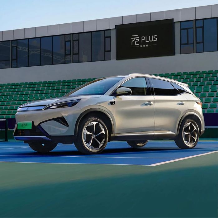 A light - colored BYD Yuan Plus electric SUV parked on a tennis court.