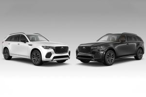 Side-by-side view of a 2025 Mazda CX-70 against a CX-90 background, showcasing contrasting color options