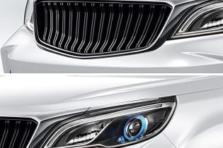 Close - up of a white car's grille and headlight.