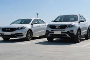 Two white cars, a sedan and an SUV, parked in an open area under a clear blue sky.
