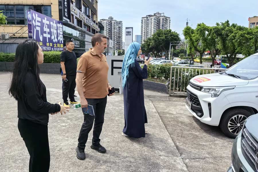 A lady is taking photographs of the car she has taken a liking to.
