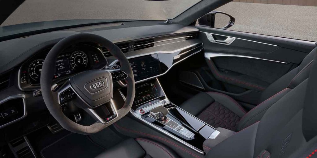 Interior of an Audi car, showcasing the steering wheel, dashboard, and front seats with a sporty design.