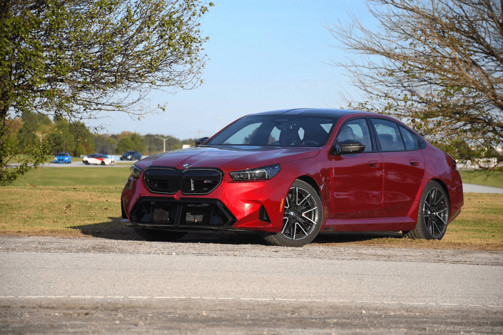 A red BMW car parked outdoors on a sunny day.