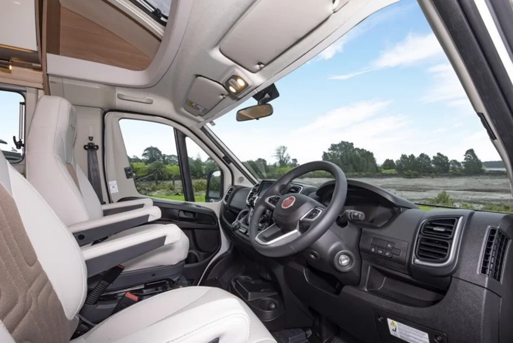 Interior of a Fiat vehicle with comfortable seats and a view of nature outside the windows.