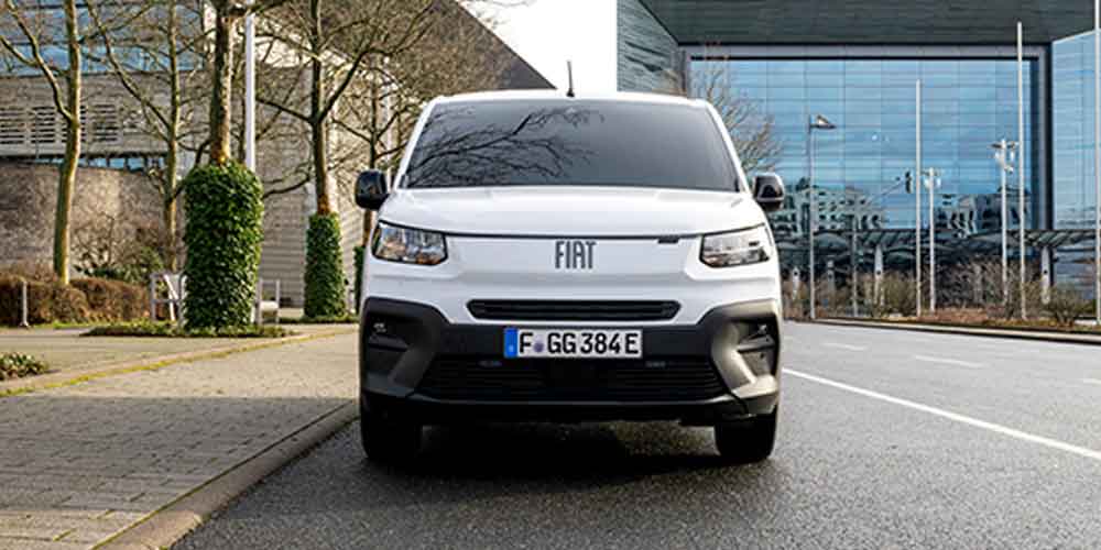 Front view of a white Fiat van with license plate F GG 384E, parked on a street in an urban area.