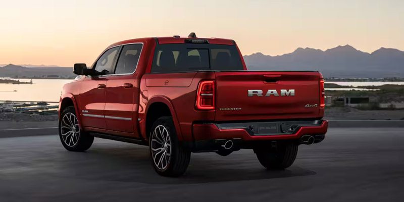 Display A driver-side rear angle of a red 2026 Ram 1500 Tungsten 4x4 Crew Cab.