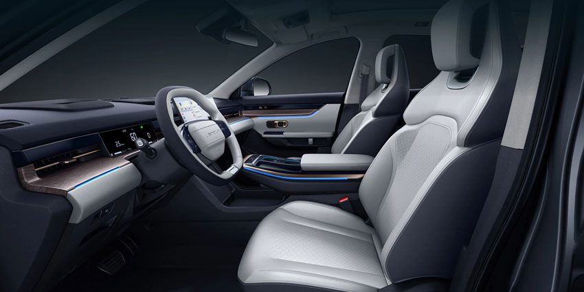 Modern car interior: light/black leather seats, digital dashboard, wood trim with blue accent lights.