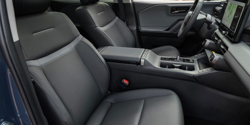 Minimalist black and gray Toyota SUV interior with textured seating, central console, and a navigation screen.