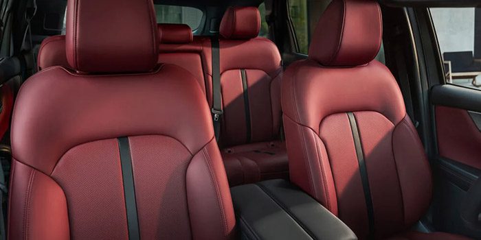 Full shot of Garnet Red Leather front and second row seating inside the 2025 Mazda CX-70