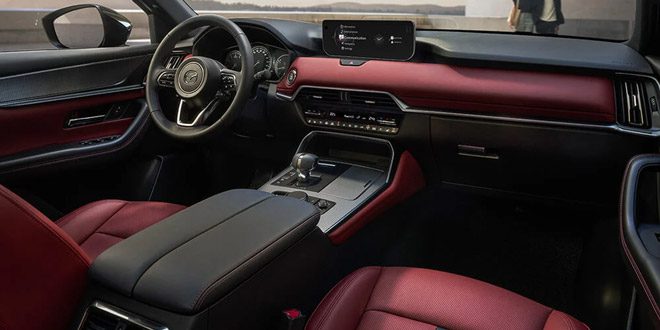 Interior shot looking out the windshield from the passenger’s seat inside a Garnet Red Leather interior 2025 Mazda CX-70