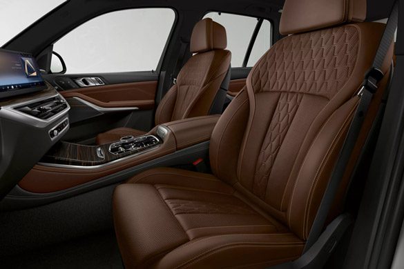 BMW X5 interior: Luxurious brown leather seats with intricate diamond-quilted stitching and premium wood trim.