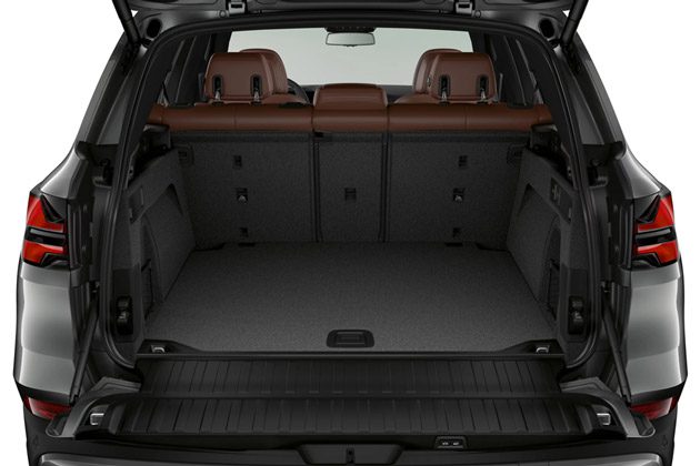 BMW X5 cargo space: Spacious trunk with folded rear seats, brown leather interior, and a durable cargo floor.