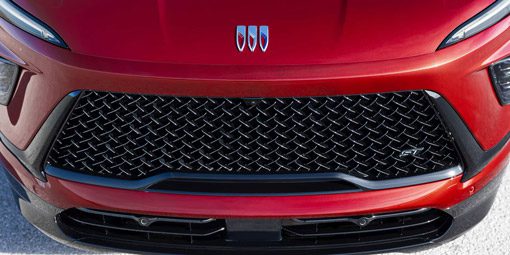 Buick front grille: Bold red SUV with a striking diamond-patterned black mesh grille and new tri-shield logo.